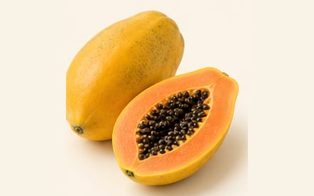 A papaya and a cut half showing the orange flesh