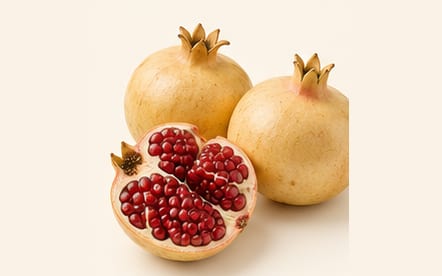 Suwari pomegranates with a cut half of glistening red seeds